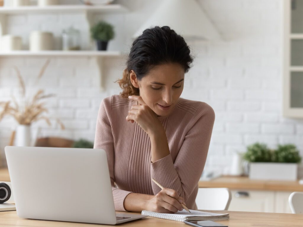 Caregiver reviewing medications at a laptop