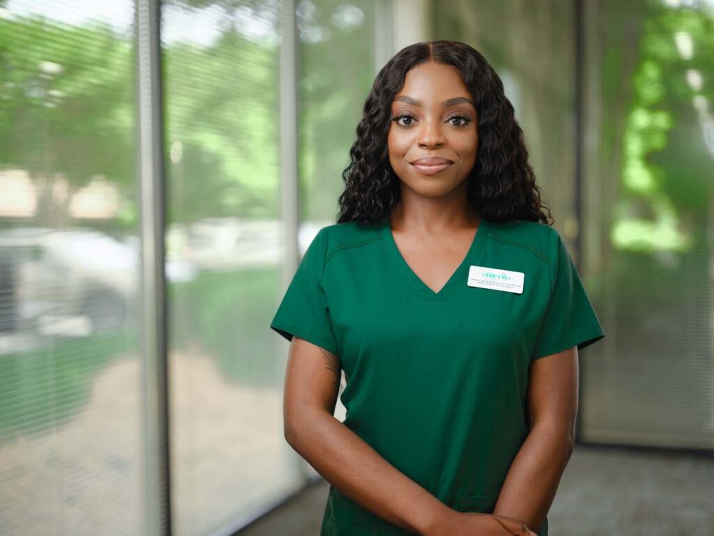 An Amerita clinician in green scrubs smiling